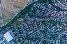Luftbild einer Kommune von oben mit Häusern und Feld